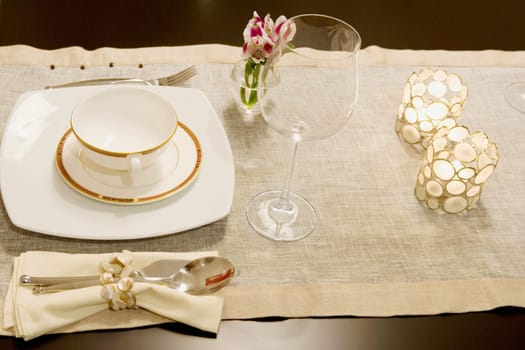 High angle view of a soup bowl with a wine glass on a dining table
