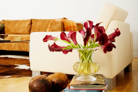 Flowers in a vase on a stack of books in a living room