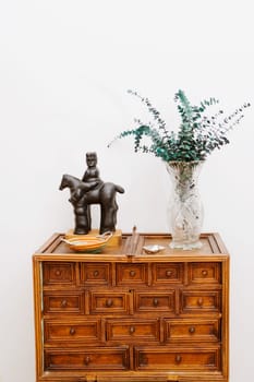 Figurine and a vase on a chest