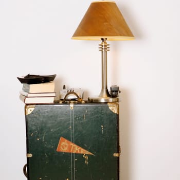 Lamp shade with a cordless phone and books on a cabinet