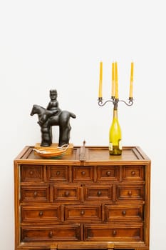 Figurine and a candlestick holder on a chest