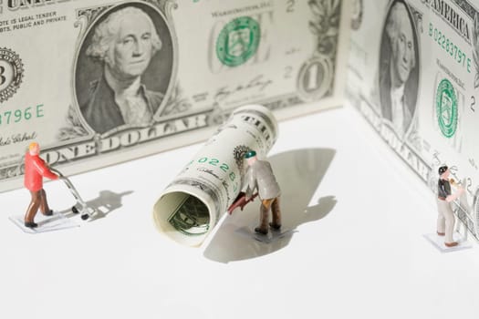 Figurines of manual workers with US dollar bills