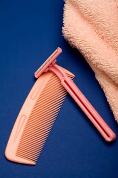 High angle view of a razor and a comb with a towel