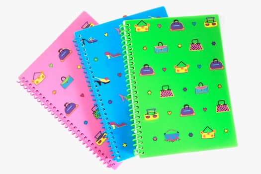 Close-up of three printed spiral notebooks