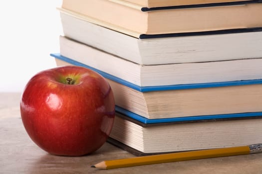 Close-up of an apple near a stack of books