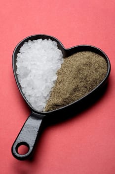 Close-up of sugar and celery seeds in a heart shaped pan