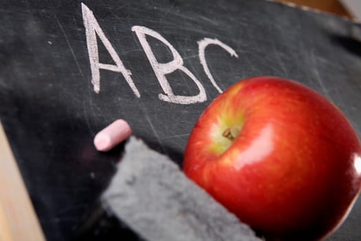 Close-up of an apple and a duster on a blackboard