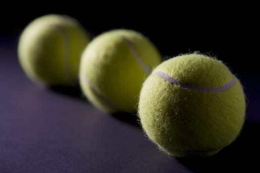 Close-up of three tennis balls in a row