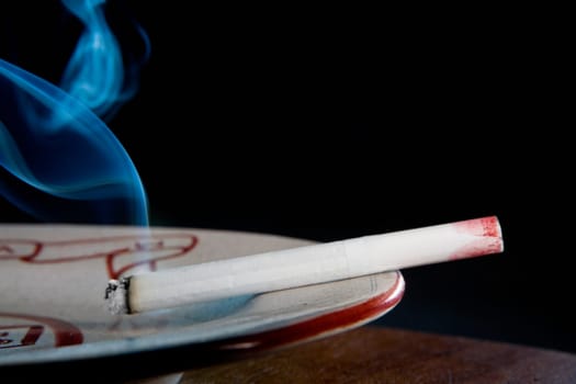 Close-up of a lipstick mark on a cigarette in an ashtray