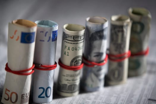 Close-up of paper currency rolls with rubber bands in a row