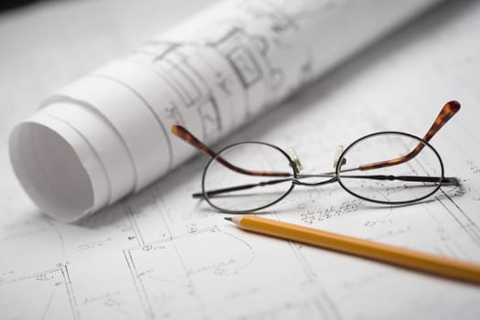 Close-up of a pencil and eyeglasses on a sheet of paper