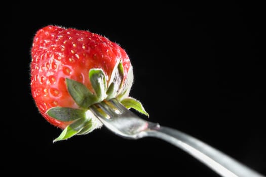 Close-up of a fork with a strawberry