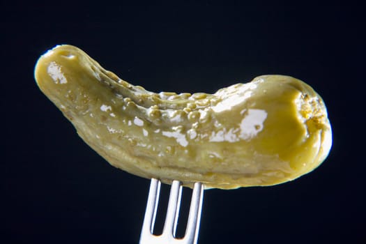 Close-up of a gherkin on a fork