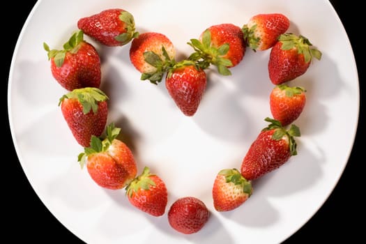 Close-up of strawberries in a plate in the shape of a heart