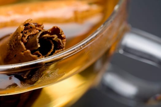 Close-up of a cinnamon stick in a bowl of cider
