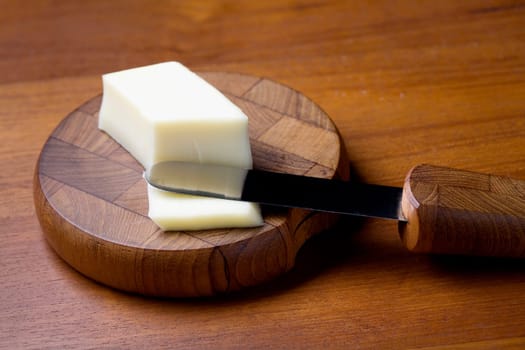 Close-up of a knife with butter and a cutting board