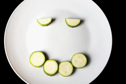 Close-up of slices of zucchini in a plate making a smiling face