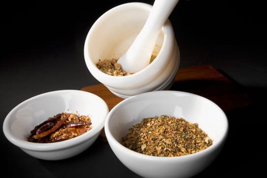 Close-up of chilli powder and turmeric powder in bowls with mortar and pestle