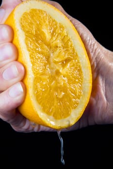 Close-up of a personŽs hand squeezing a tangerine