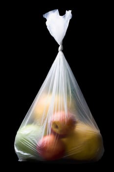 Close-up of two apples and three oranges in a plastic bag