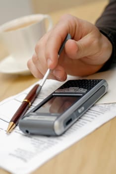 Close-up of a personŽs hand operating a personal data assistant