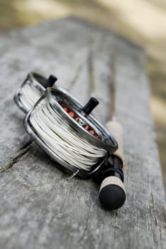 Close-up of two fishing reels and a fishing rod