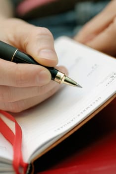 Close-up of a personŽs hand writing in a diary
