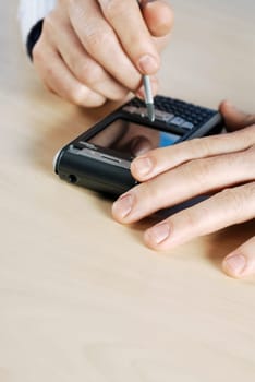 Close-up of a personŽs hand operating a personal data assistant