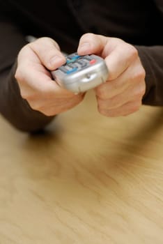 Close-up of a manŽs hand operating a remote control