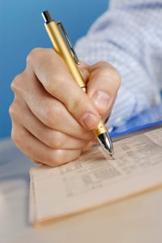Close-up of a personŽs hand writing with a ballpoint pen on a sheet of paper
