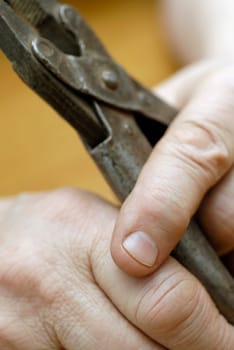 Close-up of a personŽs hands holding a pair of pliers