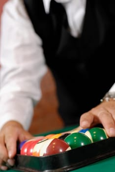 Mid section view of a man racking up pool balls on a pool table