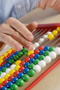 Close-up of a personŽs hand counting beads on an abacus
