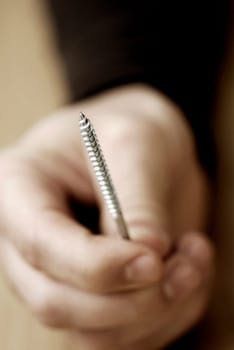 Close-up of a personŽs hand holding a screw