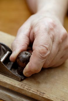 Close-up of a personŽs hand using a wood planer