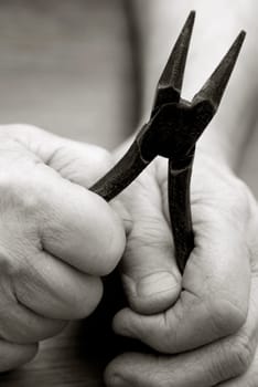 Close-up of a personŽs hands holding a pair of pliers