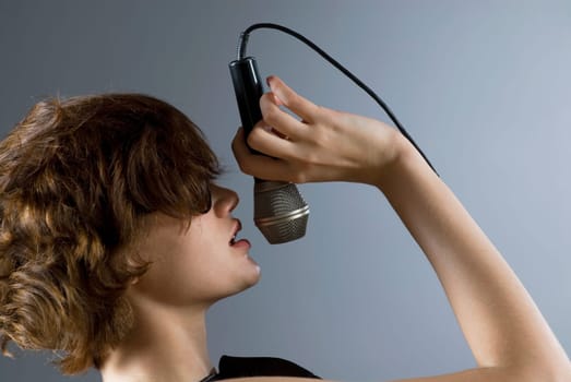 Close-up of a young woman singing into a microphone