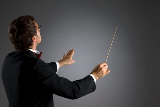 Side profile of a music conductor performing