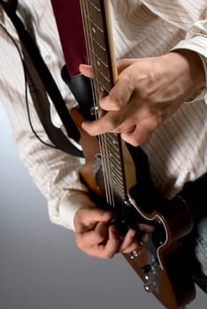 Mid section view of a male guitarist playing a guitar