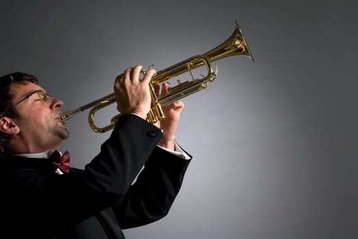 Side profile of a musician playing a trumpet