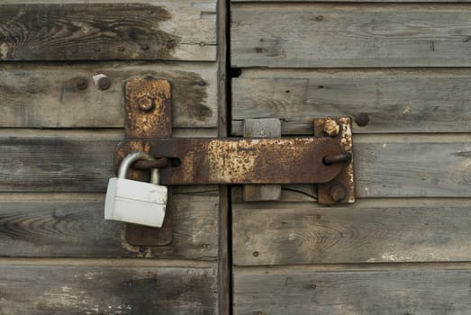 Close-up of a wooden door with a padlock
