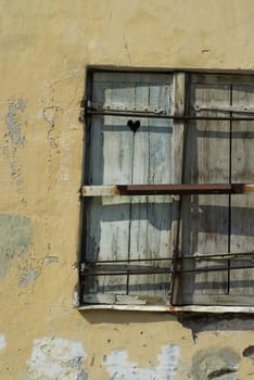 Close-up of an old window on a weathered wall