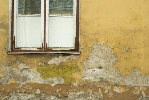 Close-up of an old window on a weathered wall