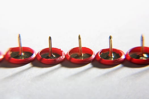 Close-up of five thumbtacks in a row