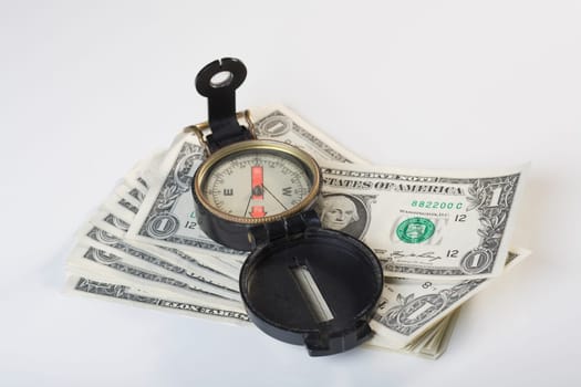 Close_up of a compass on a stack of US dollar bills