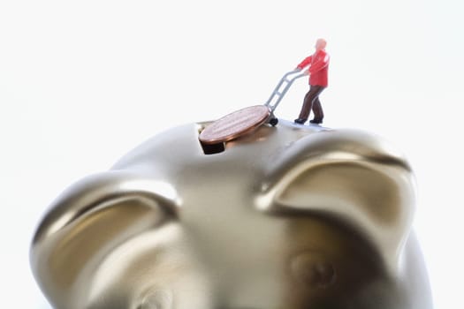 Figurine of a man putting a coin into a piggy bank