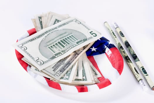 US dollar bills with an American flag and pencils