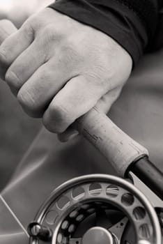 Close-up of a personŽs hand holding a fishing rod and a fishing reel
