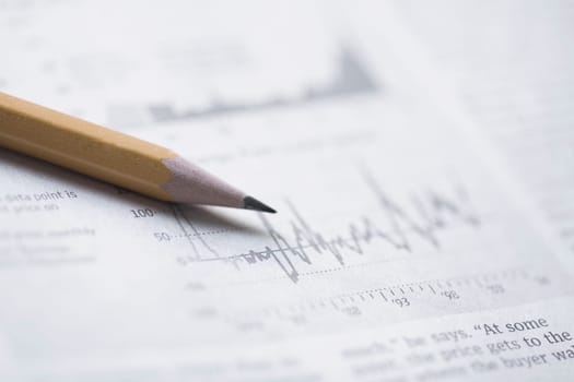 Close_up of a pencil on a financial newspaper