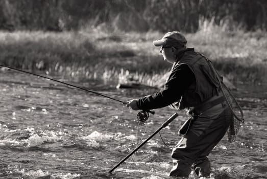 Side profile of a mature man fishing in the river